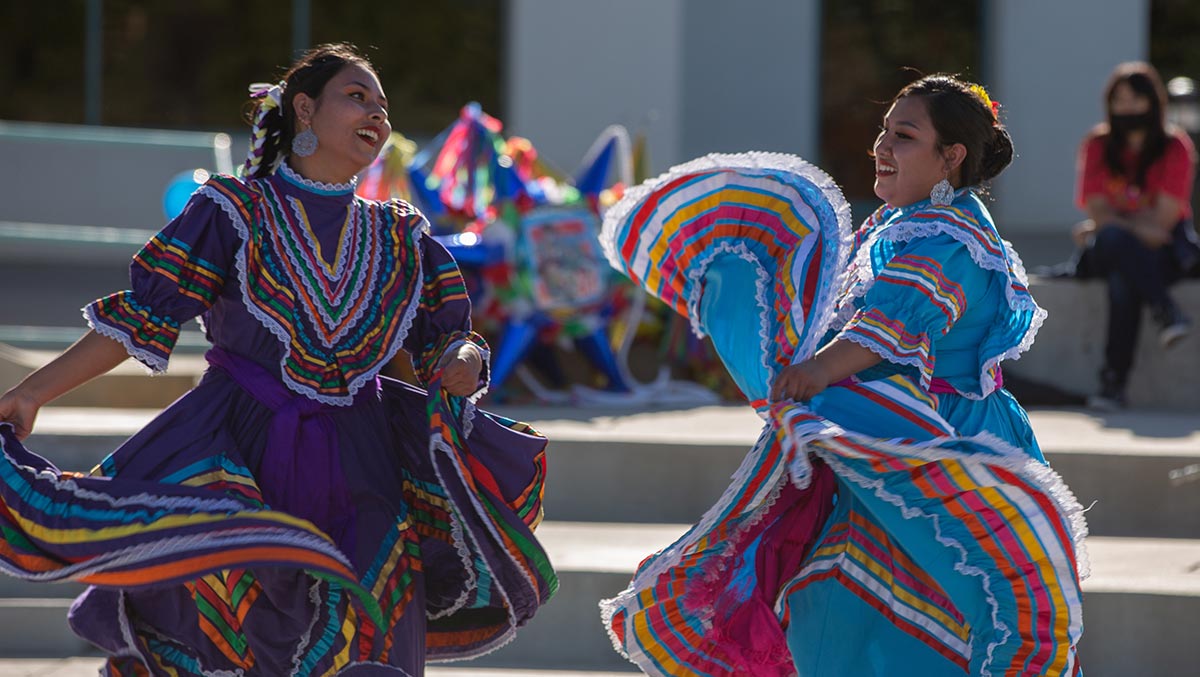Students at the fiesta at sunset in traditional dress dancing