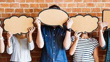 Three people stand with cardboard covering their faces.