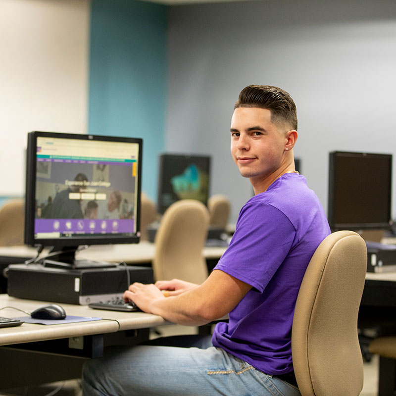 Student sitting at the computer in his IT class.