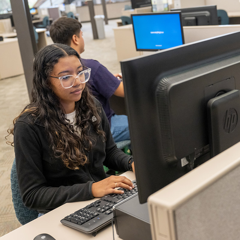 SJC Student sitting in front of a computer typing