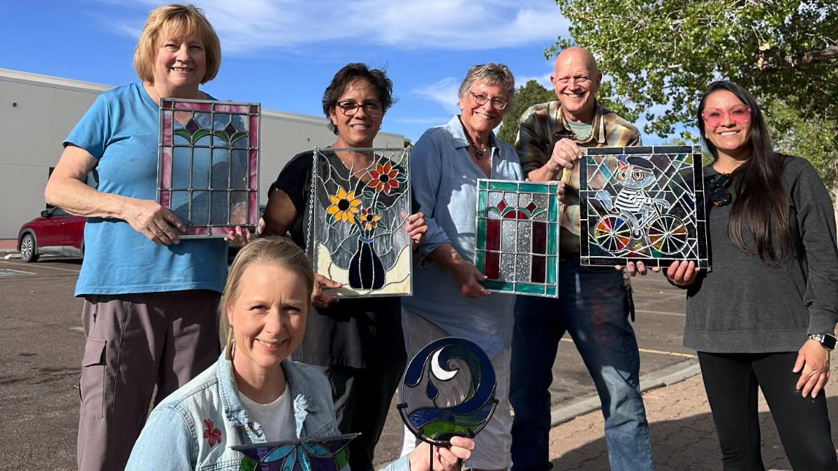 Group of Encore students holding their stained glass artwork
