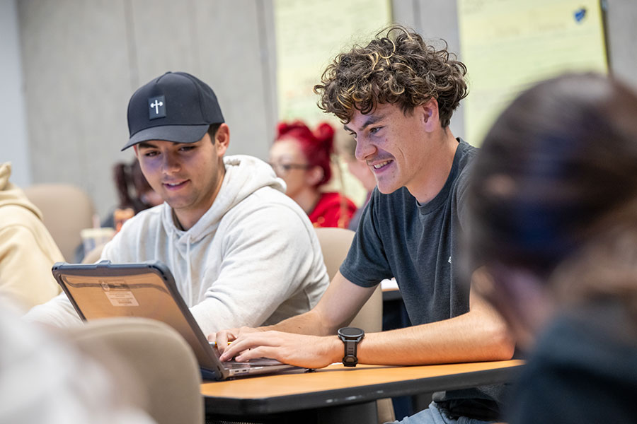 Two SJC Students in their humanities class working on the computer