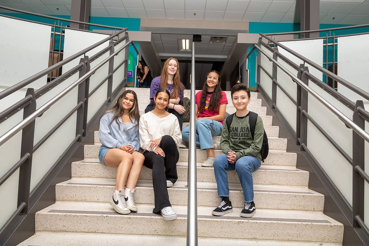 Group of SJC students sitting on the stairs in the West Classroom Complex on the SJC Main Campus