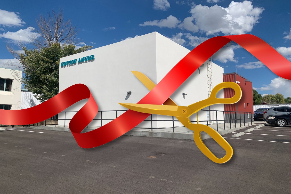 South Hutton Annex San Juan College with a red ribbon being cut with scissors.