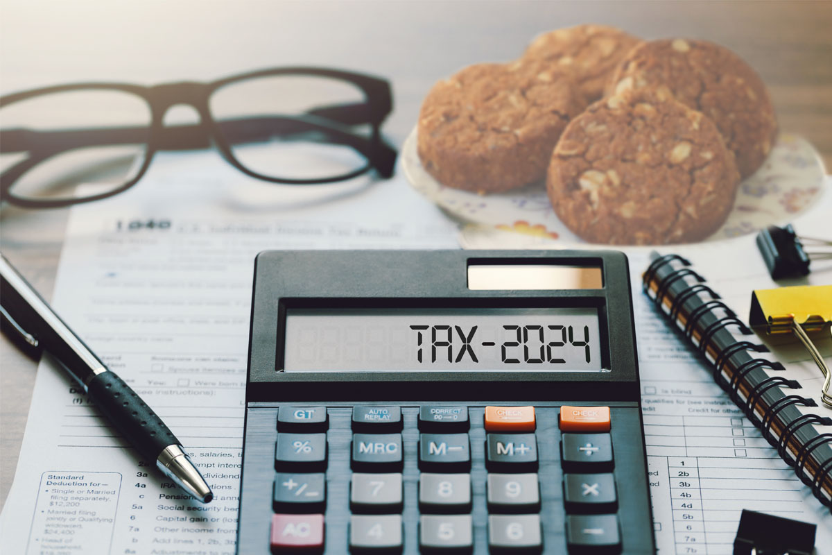 Glasses, cookies and a calculator that reads TAX 2024
