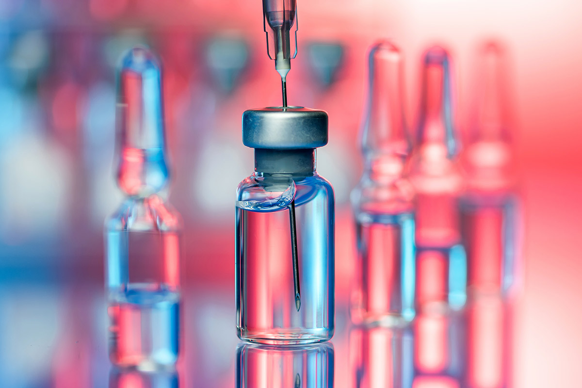 A vaccine vile with a needle inside.