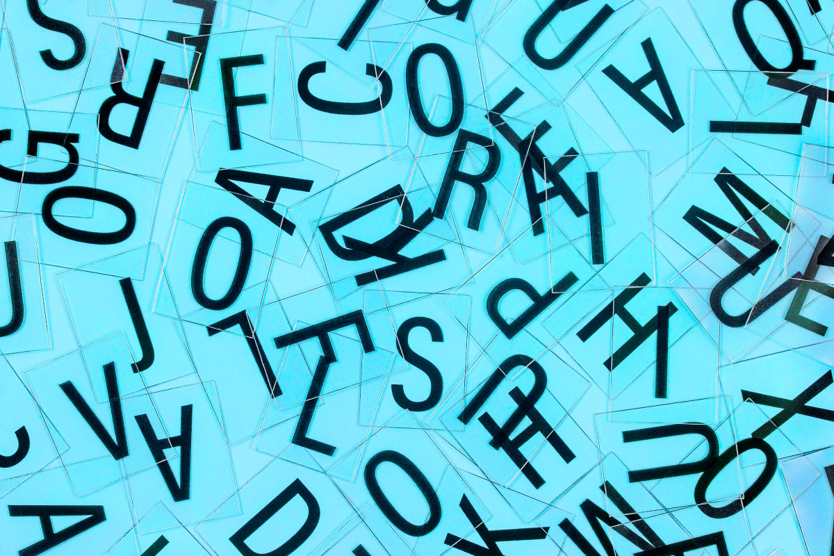 A variety of letters on tiles scatters on a blue background