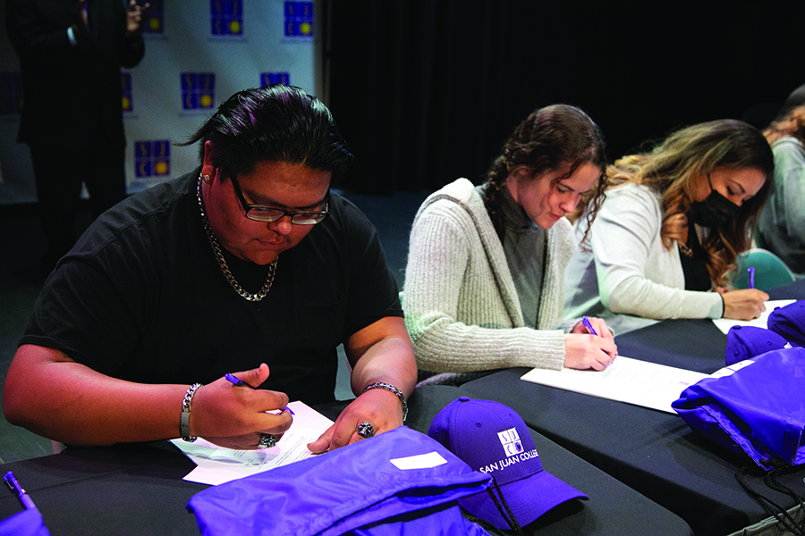 Three students signing at National Letter of Intent Signing Day 2022 Annual Report