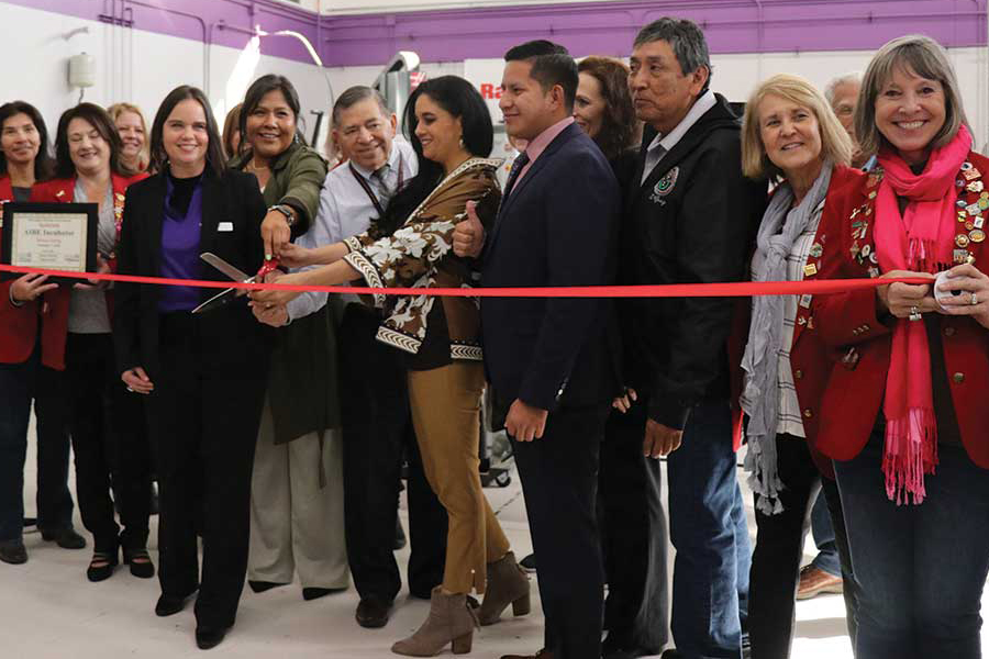 Individuals standing in front of a ribbon cutting