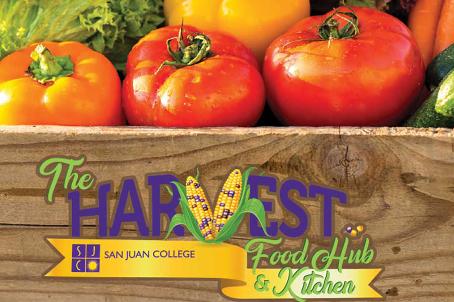 Harvest Food Hub San Juan College written on brown wooden box filled with produce