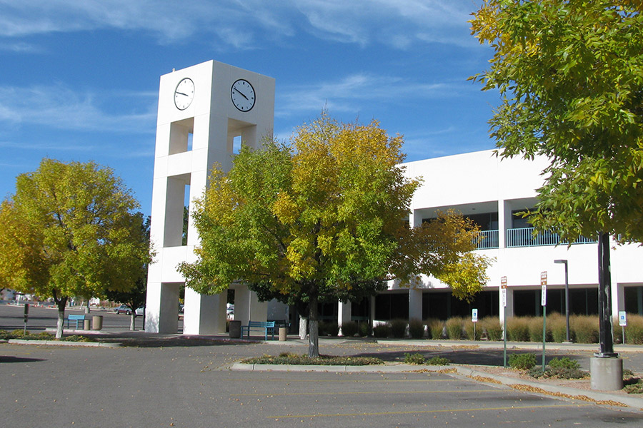 western view of the san juan college educational services building with the clocktower in the forefront, trees changing colors to yellow and gold.