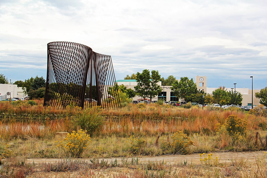 The energy sculpture is shown in the foreground with the clocktower building in the background.