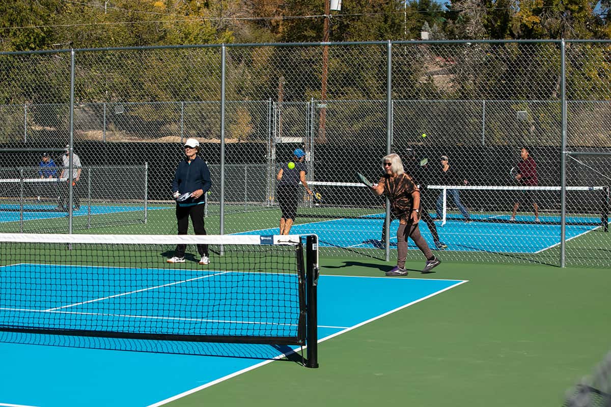 Pickleball player readies to return hit back to other player on a sunny day at the Brookside Park Pickleball courts.