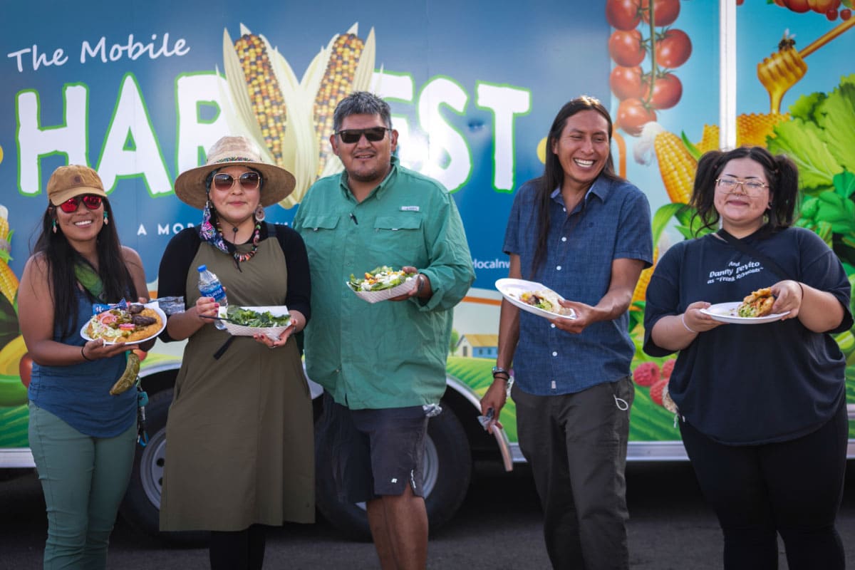 Five people standing in front of Harvest Food Hub Truck