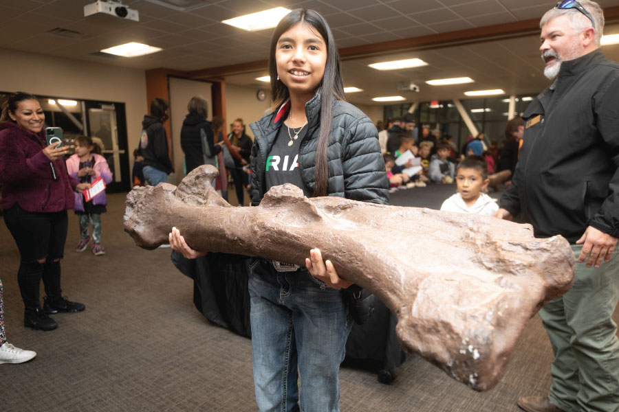 A Kids Kollege student holding a fossil in the Dugan Museum of Geology in the School of Energy!