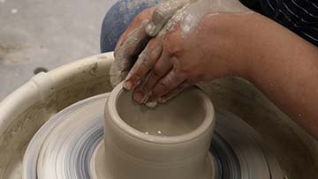 Hands using pottery wheel