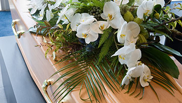 Flower arrangement lying on casket.