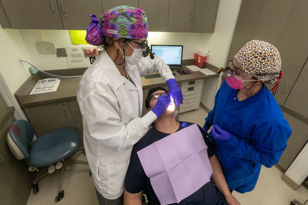 Two San Juan College dental students work on a patient