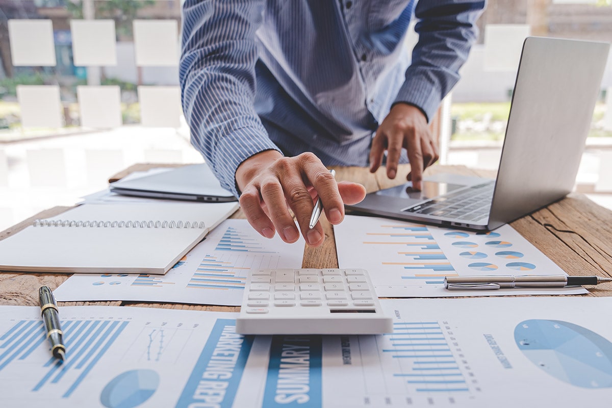 Student working on a calculator and laptop.