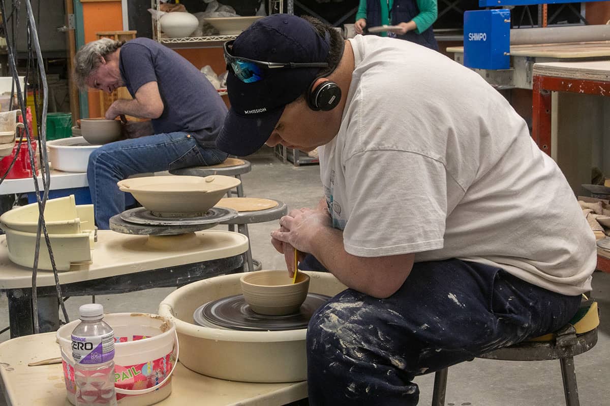Student on the pottery wheel in the General Education Transfer Certificate Program