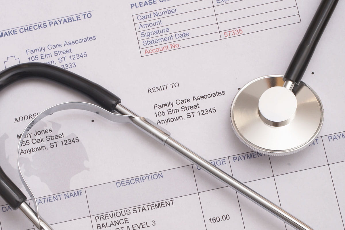 A paper billing statement with a stethoscope laid on top