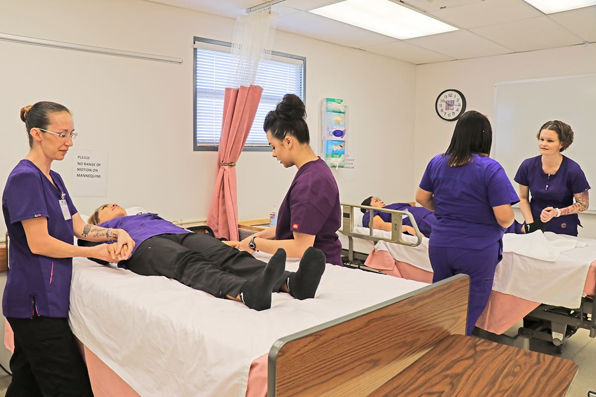 nursing cna students work through exercise on basic patient care.