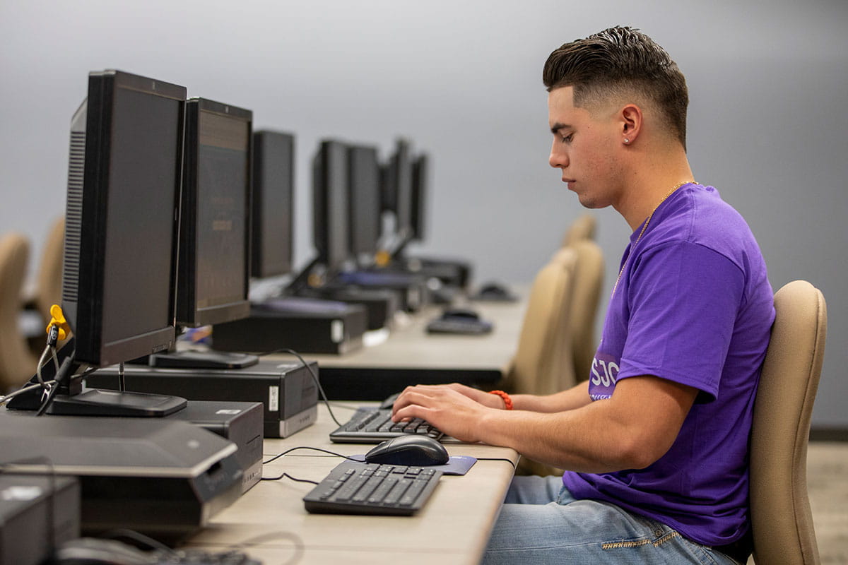 A San Juan College student using a computer in an on-campus computer lab