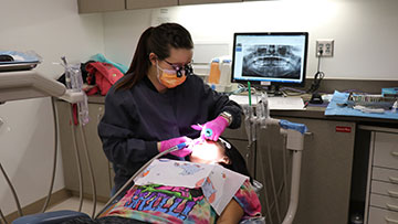 Dental Hygienist cleaning a patient's teeth.