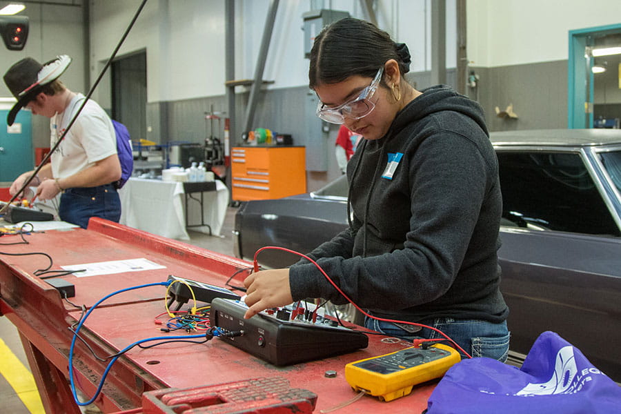 Two San Juan College students using diagnostic tools in the automotive repair shop