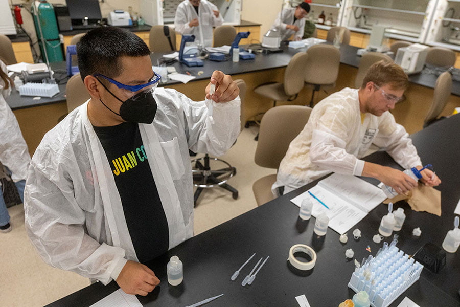 Two San Juan College students preparing samples in the chemistry lab