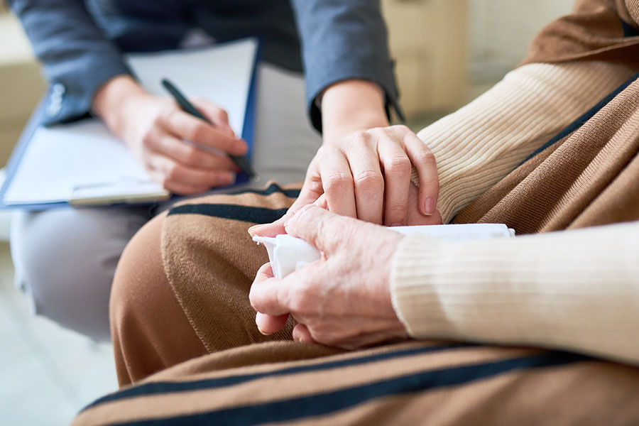 A counselor supporting a patient by holding their hands