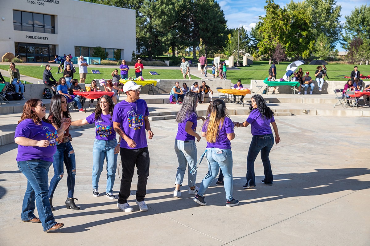 students enjoying dancing at the fiesta at sunset celebration in learning commons plaza