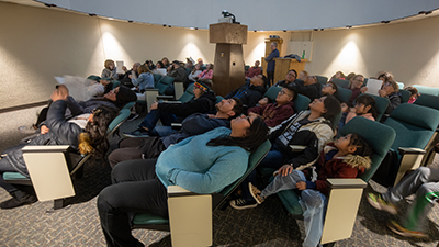 People sitting in the planetarium viewing an AstroFriday show.