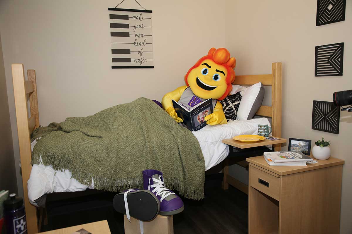 SJC Mascot, Blaze, in a dorm room.