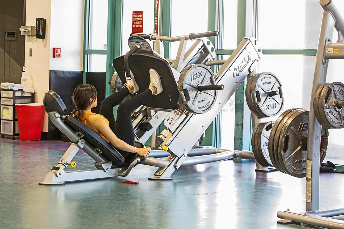 Female student works out with leg press in hhpc.