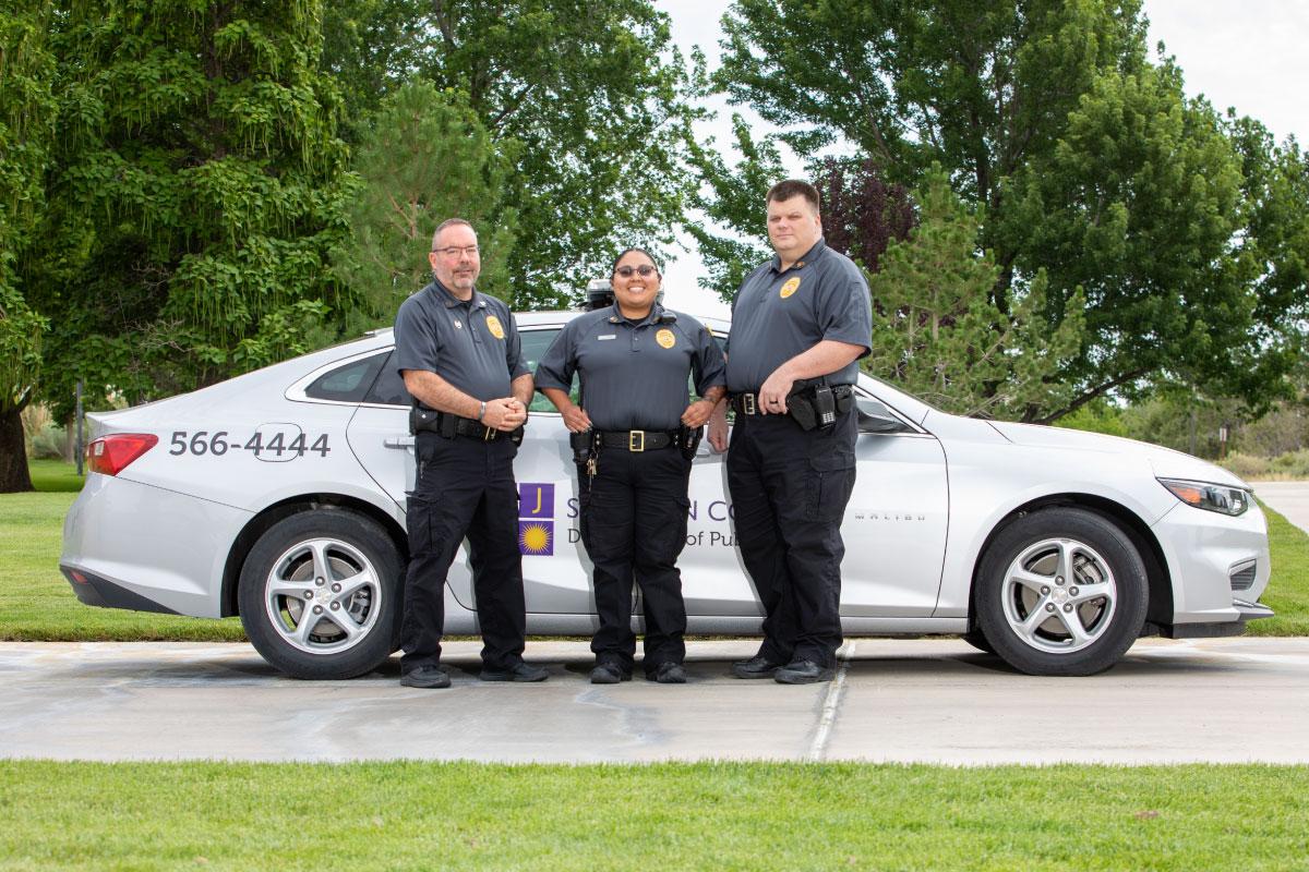 Three SJC Campus Security Officers stand in front of patrol car