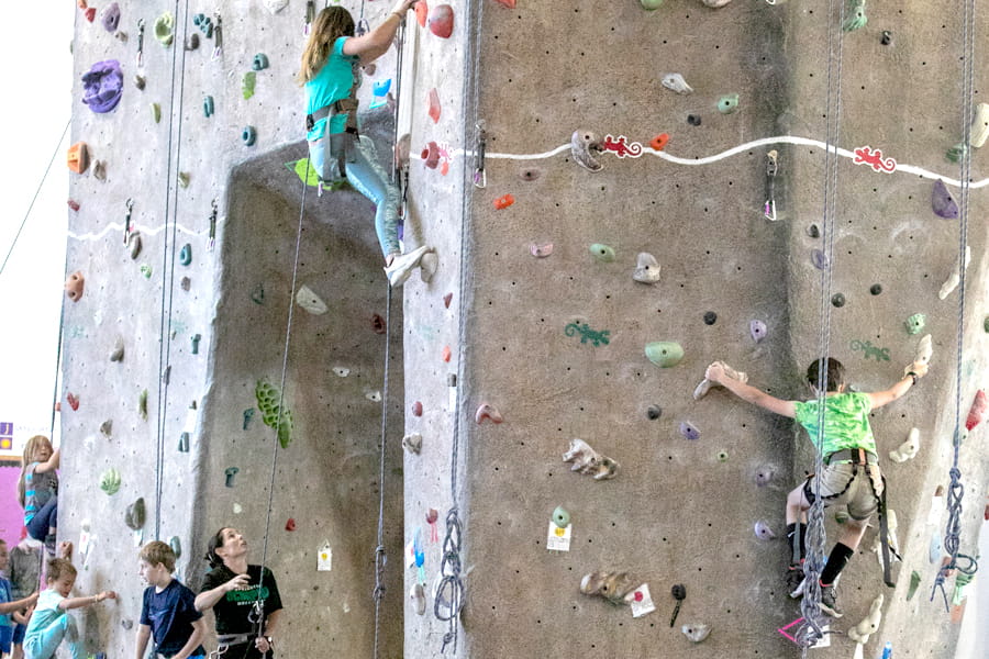 Two kids climbing the indoor rock wall at the Health and Human Performance Center